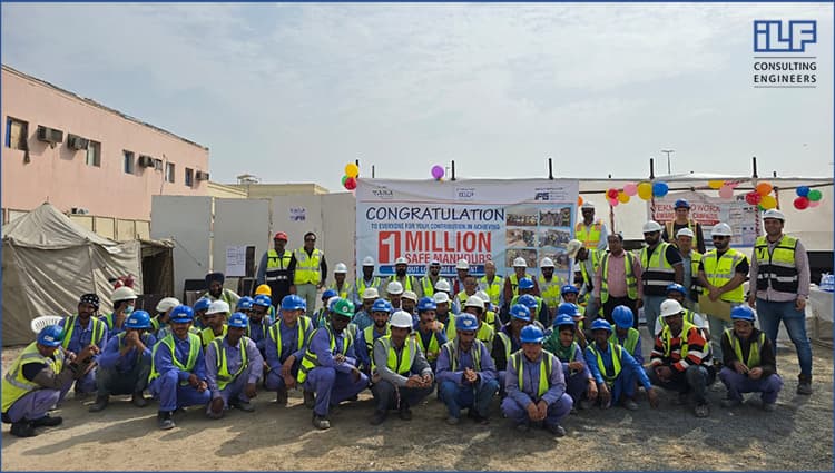 A group of construction workers smiling and posing together for a photo on a job site.